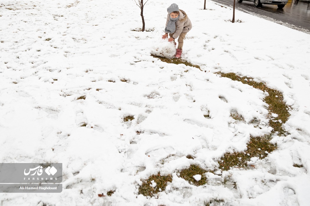 کودکی در حال برف بازی و تفریح در پارک  ائل گلی هستند.